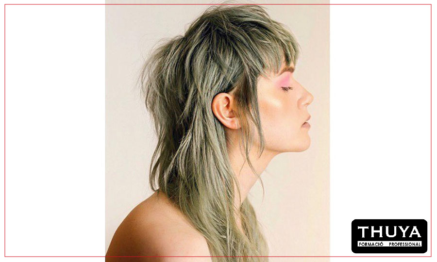 modelo de perfil mostrando su corte de pelo Mullet