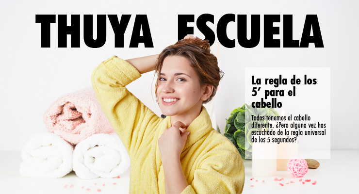 chica blanca con cabello rubio sonriente con bata de baño amarilla aparece sobre un fondo claro con productos de baño mientras sostiene su cabello